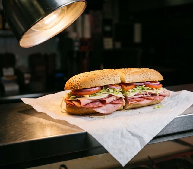A deli sub on a seeded roll, cut in half